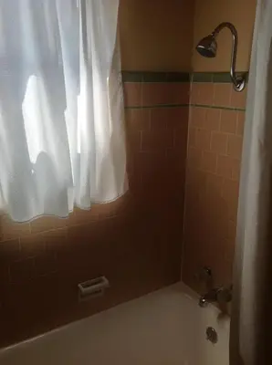 a bathroom with a tub and a shower with a curtain at Historic Dow Hotel in Lone Pine