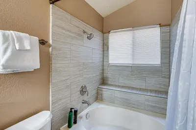 a bathroom with a white tub and a shower at Cozy Antelope Home about 14 Mi to Sacramento! in Antelope