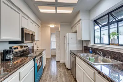 a kitchen with a sink and a refrigerator at Cozy Antelope Home about 14 Mi to Sacramento! in Antelope