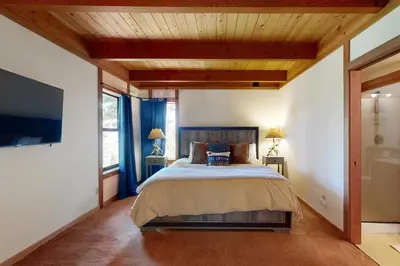 a bedroom with a large bed and a flat screen tv at Timberline Daydream in Truckee