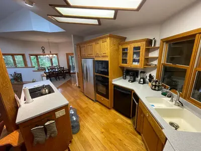 a kitchen with wooden cabinets and a counter top at RiverFront Retreat- Spa/Hot tub, Game Room, Limited Gym in Three Rivers