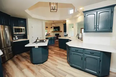 a kitchen with dark blue cabinets and white counter tops at Riverfront Beauty with Pickle Ball Court in Kingsburg