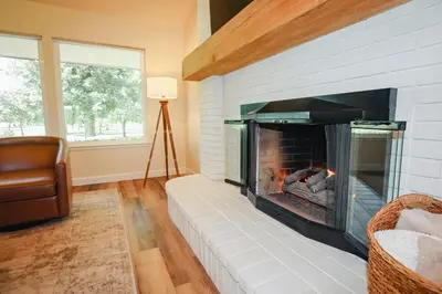 a living room with a fireplace and a couch at Riverfront Beauty with Pickle Ball Court in Kingsburg