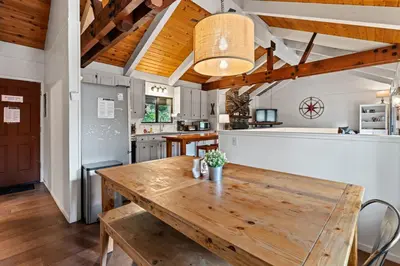 a dining room with a wooden table and a kitchen at Trailblazer Chalet at Olympic Valley with Private Hot Tub and Ski Shuttle in Alpine Meadows