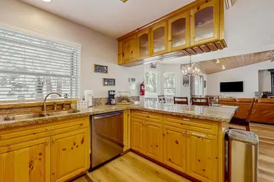 a kitchen with wooden cabinets and a large window at A Taste of Tahoe in Tahoe Vista