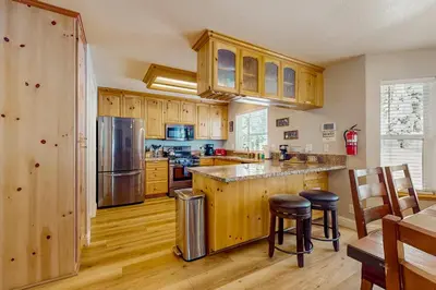 a kitchen with wooden cabinets and stainless steel appliances at A Taste of Tahoe in Tahoe Vista