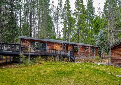 a log cabin in the woods with a deck at Oso Borracho in Arnold