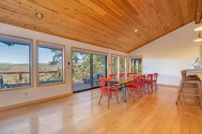 a dining room with a table and chairs and windows at Murphys View in Murphys