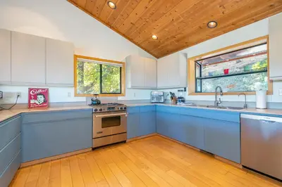 a large kitchen with blue cabinets and a wooden ceiling at Murphys View in Murphys