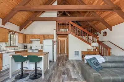 a kitchen and living room with wooden ceilings at Moonlit Pines in Camp Connell