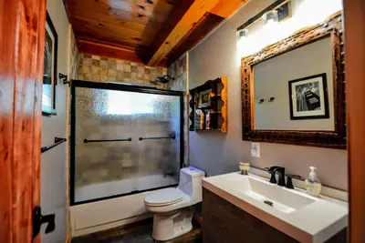 a bathroom with a toilet and a sink and a mirror at Grey Wolf Manor in Arnold
