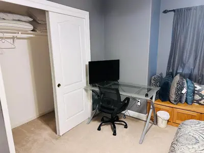 a bedroom with a desk with a computer and a bed at serenity in Fresno