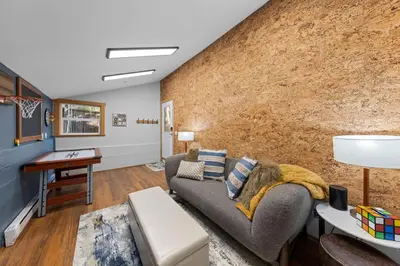 a living room with a couch and a brick wall at Hideaway in the Highlands - 4BR, Pet Friendly w Hot Tub - Minutes from the Lake & Tahoe City in Tahoe City