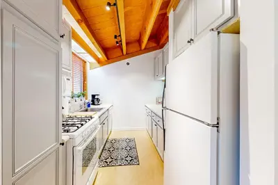 a kitchen with white appliances and a wooden ceiling at Northstar Nirvana in Truckee