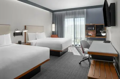 a hotel room with two beds and a desk at Courtyard by Marriott Modesto North in Modesto