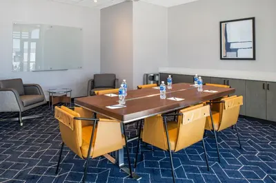 a conference room with a table and yellow chairs at Courtyard by Marriott Modesto North in Modesto