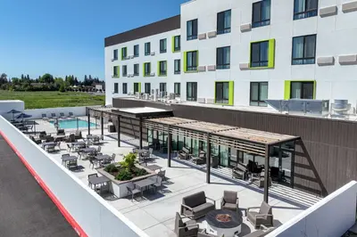 an outdoor patio with tables and chairs on a building at Courtyard by Marriott Modesto North in Modesto