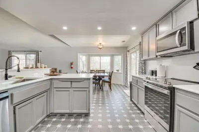 a kitchen with white cabinets and a table with chairs at Bright and Cozy Mariposa Getaway 46 Mi to Yosemite! in Mariposa