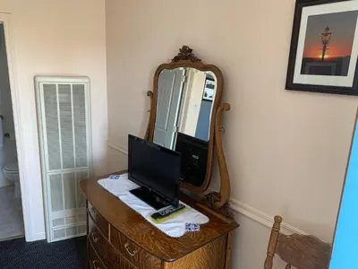 a computer sitting on a dresser with a mirror at Sugarloaf Mountain Motel in Virginia City