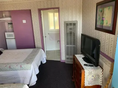 a hotel room with two beds and a flat screen tv at Sugarloaf Mountain Motel in Virginia City