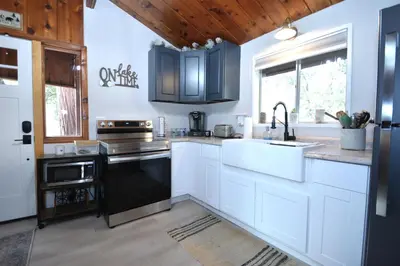 a kitchen with white cabinets and black appliances at Bear Paw- Lake Area Winter Special Ends 51526 in Bass Lake