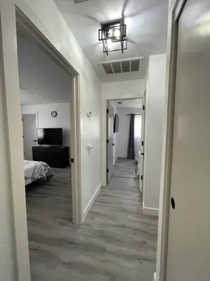 a hallway of a room with a bed and a mirror at Entire Modern House with King bed & 65inTV in Carmichael