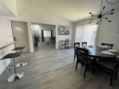 a dining room and living room with a table and chairs at Entire Modern House with King bed & 65inTV in Carmichael