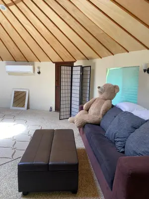 a teddy bear sitting on a couch in a room at Seven Circles Lodge&Retreat in Badger
