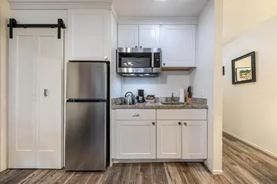 a kitchen with a stainless steel refrigerator and white cabinets at Delightful Studio w/Kitchenette #111 at Donner Lake Village in Truckee