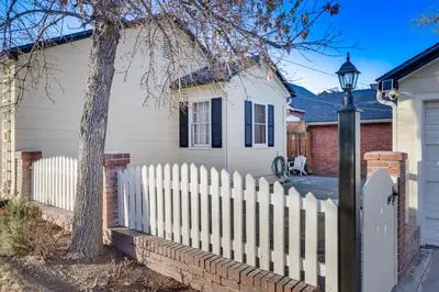 a white fence in front of a white house at Less Than 1 Mi to Midtown Pet-Friendly Home in Reno! in Reno