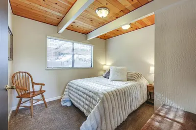 a bedroom with a bed and a chair and a window at Serene Cabin Retreat Between Murphys and Arnold in Murphys