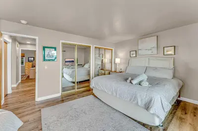 a bedroom with a large white bed and a mirror at Big Blue Views Walk 2 Lake in Tahoe Vista