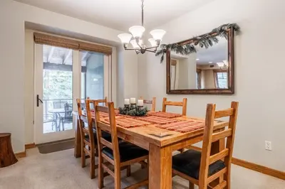 a dining room with a table and chairs and a mirror at Upscale 4 Bed, 3 Bath at the Woodwinds with Amazing Mountain Views and Golf Course Access and private hot tub and garage sleeps 10 in Mammoth Lakes