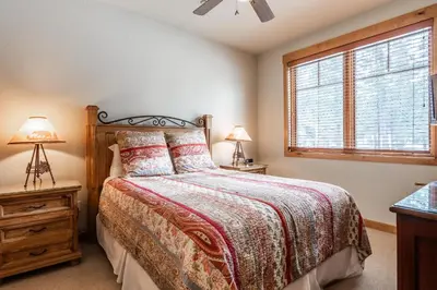 a bedroom with a bed and a window at Upscale 4 Bed, 3 Bath at the Woodwinds with Amazing Mountain Views and Golf Course Access and private hot tub and garage sleeps 10 in Mammoth Lakes