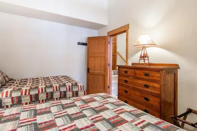 a bedroom with two beds and a dresser with a lamp at Upscale 4 Bed, 3 Bath at the Woodwinds with Amazing Mountain Views and Golf Course Access and private hot tub and garage sleeps 10 in Mammoth Lakes