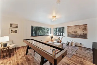 a living room with a table in the middle at The Pinecrest Retreat- 10 mins to NorthStar! Hot Tub, Large Deck, Views, and Games in Tahoe Vista