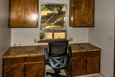 a room with a desk with a chair and a window at The Badger House in Badger
