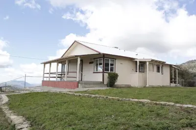 a small white house on a grassy field at Hummingbird Hill - Entire Cabin in Dunlap