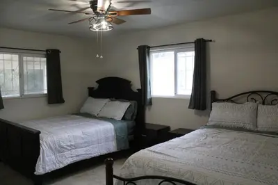 a bedroom with two beds and a ceiling fan at Hummingbird Hill - Entire Cabin in Dunlap