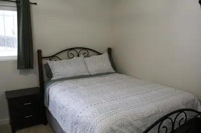 a bedroom with a bed with white sheets and a window at Hummingbird Hill - Entire Cabin in Dunlap