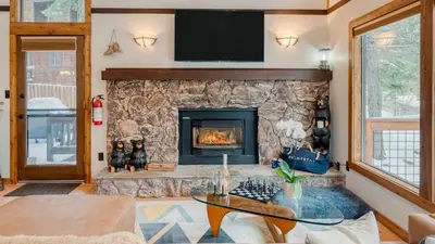 a living room with a stone fireplace at In Northstar Ski Resort Game Room Family-Friendly Dakine Haus by AvantStay in Truckee