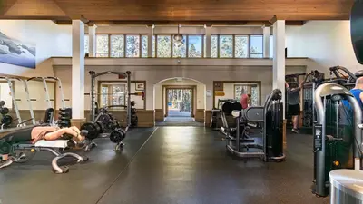 a gym with tread machines and a woman laying on the floor at In Northstar Ski Resort Game Room Family-Friendly Dakine Haus by AvantStay in Truckee