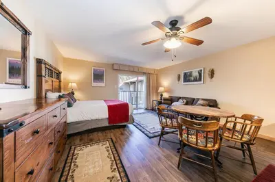 a bedroom with a bed and a table and chairs at Charming Studio Deluxe w/kitchen #215 at Donner Lake Village in Truckee