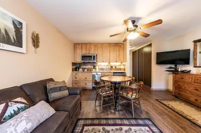 a living room with a couch and a table at Charming Studio Deluxe w/kitchen #215 at Donner Lake Village in Truckee