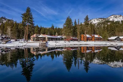 a reflection of a lodge in a lake with snow at Charming Studio Deluxe w/Full Kitchen #115 at Donner Lake Village in Truckee