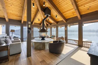 a living room with a couch and a table and windows at Charming Studio Deluxe w/Full Kitchen #115 at Donner Lake Village in Truckee