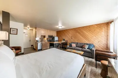 a hotel room with a bed and a kitchen at Lovely Studio w/Kitchen and Partial Lake View #122 at Donner Lake Village in Truckee