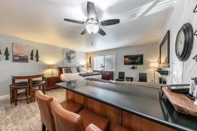 a living room with a bed and a ceiling fan at Partial Lake View Stunning Deluxe King Studio #125 at Donner Lake Village in Truckee