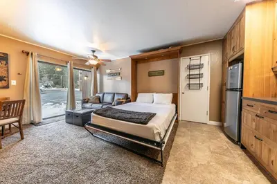 a bedroom with a bed and a living room at Cozy Studio 1st Floor #132 at Donner Lake Village in Truckee