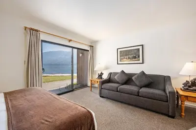a bedroom with a bed and a couch and a window at Cozy King Studio w/Lake View #145 at Donner Lake Village in Truckee